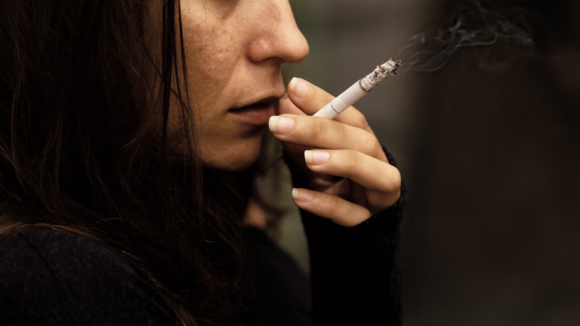 Eine Frau hält eine Zigarette in der Hand