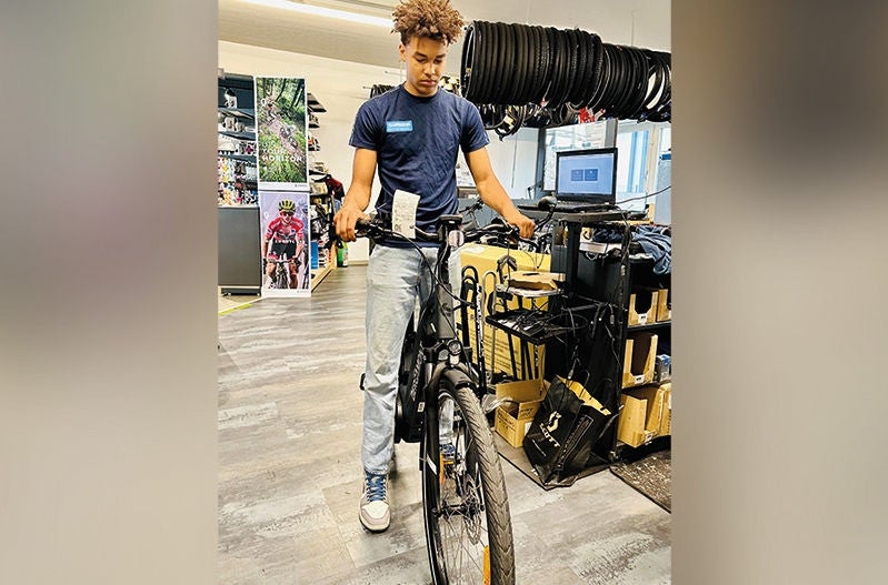 ein junger Mann prüft ein Fahrrad