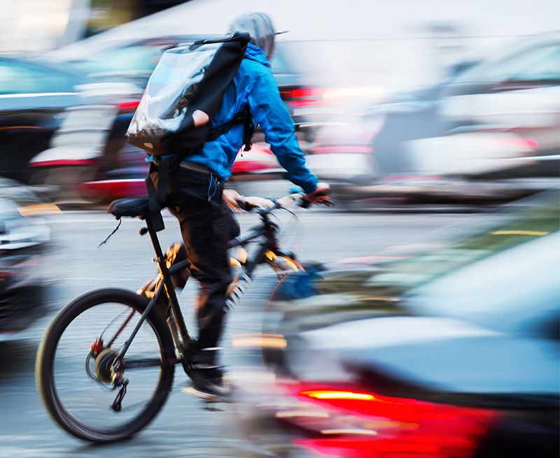 bicycle messenger in busy city traffic