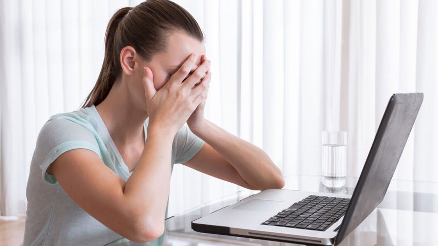 verzweifelte Frau vorm Laptop