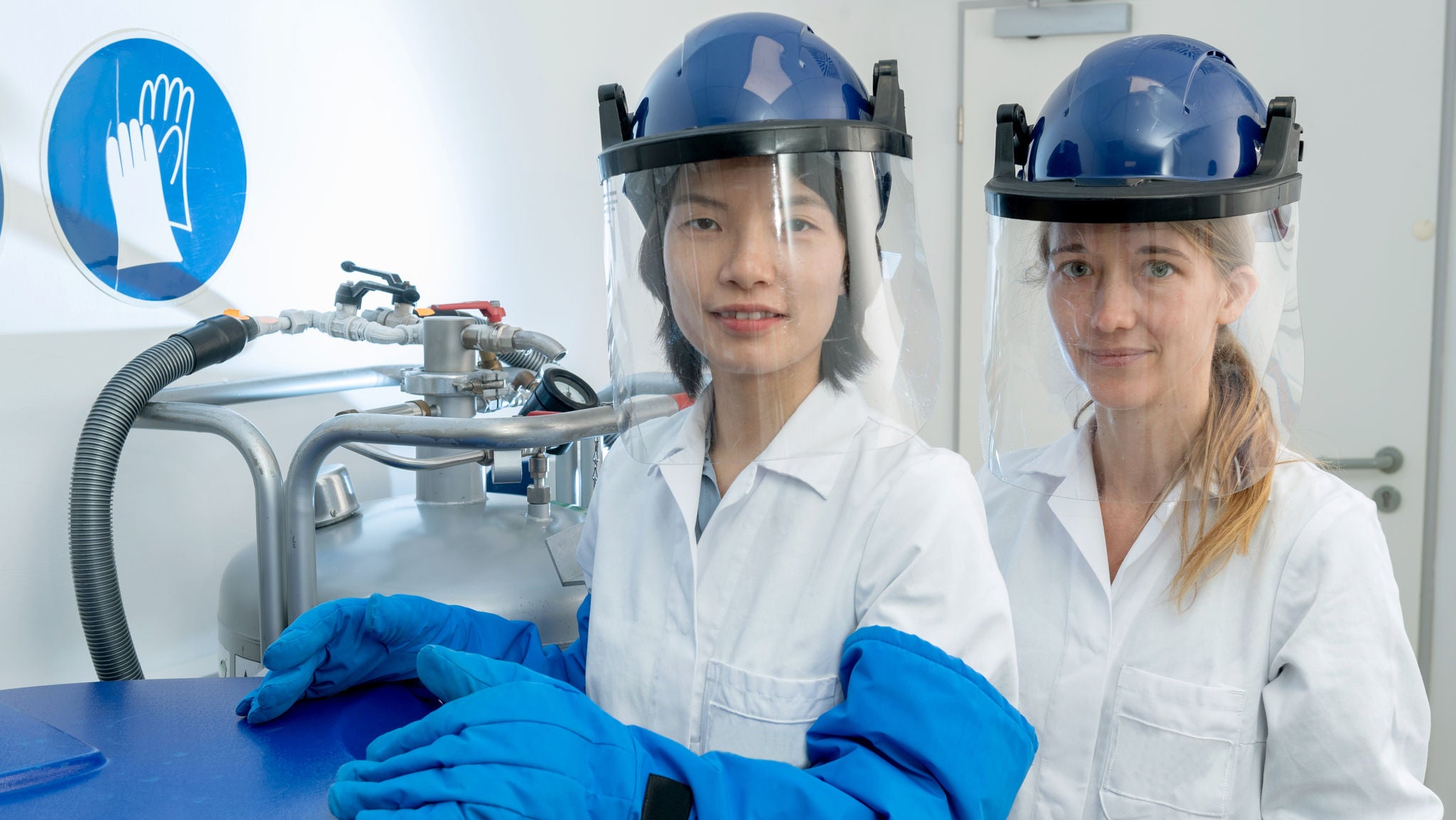 Mitarbeiterinnen eines Labors in voller Schutzausrüstung