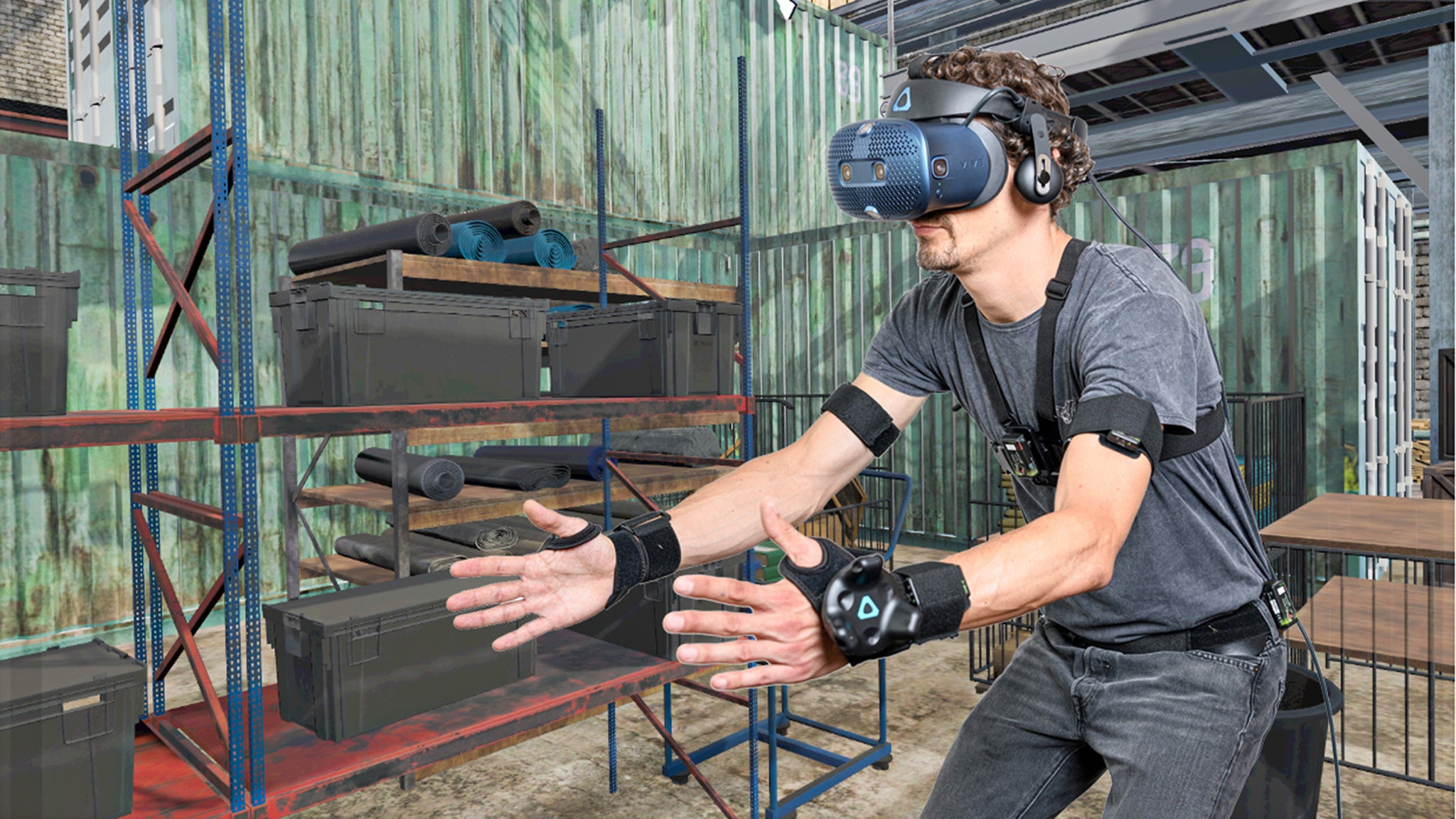 Fotomontage: Im Vordergrund sieht man einen Mann mit VR-Brille und zahlreichen Sensoren vor dem virtuellen Hintergrund eines Lagers