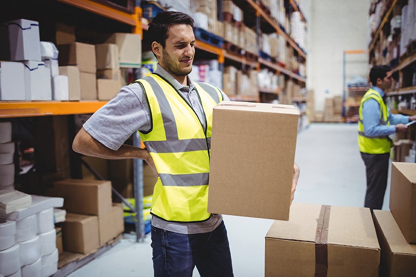 Mann mit schmerzverzehrten Gesicht bei der Arbeit