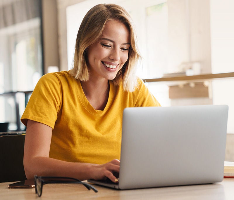 Photo of joyful nice woman using laptop and smiling while sitting, Photo of joyful nice woman using laptop and smiling while sittin