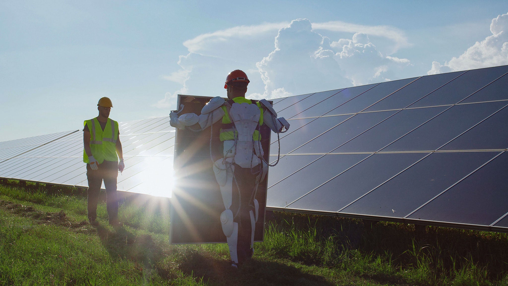 Ein Arbeiter trägt ein Solarpaneel zu seinem Kollegen