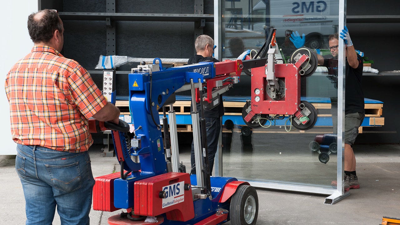 Ein Roboter hilft beim Anheben einer großen Glasplatte