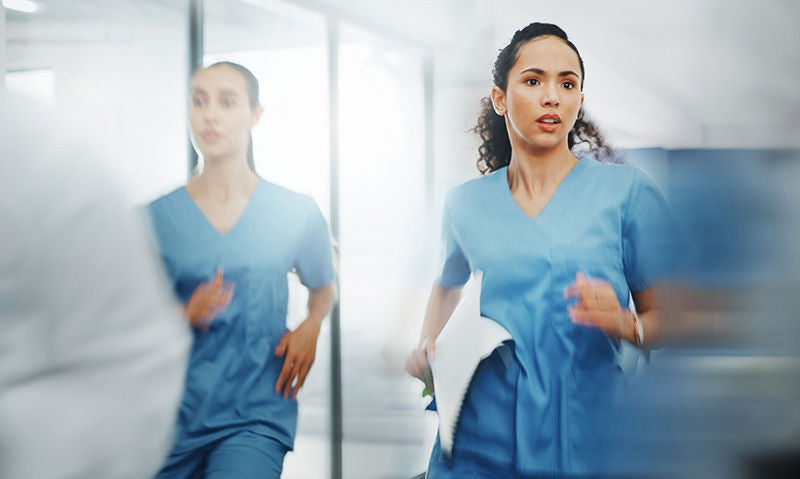 Pflegekräfte laufen in einer Notfallsituation durch den Klinikflur.
