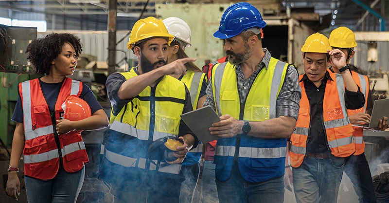 Team Workers and workers are standing in the factory. Group Staff Standing In Engineering Factory., Team Workers and workers are standing in the factory. Group Staf