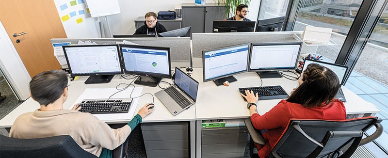 Ansicht von oben auf ein Büro mit Personen, die an ihren Computern arbeiten