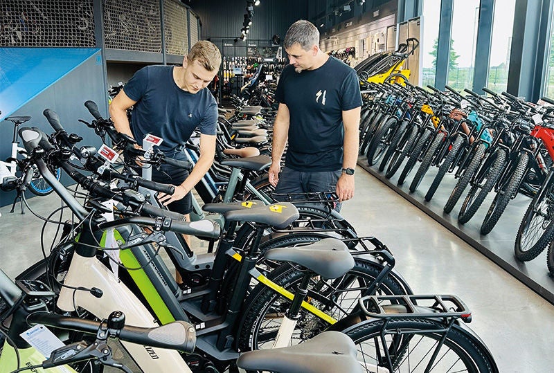 zwei junge Männer inmitten von vielen Fahrräden