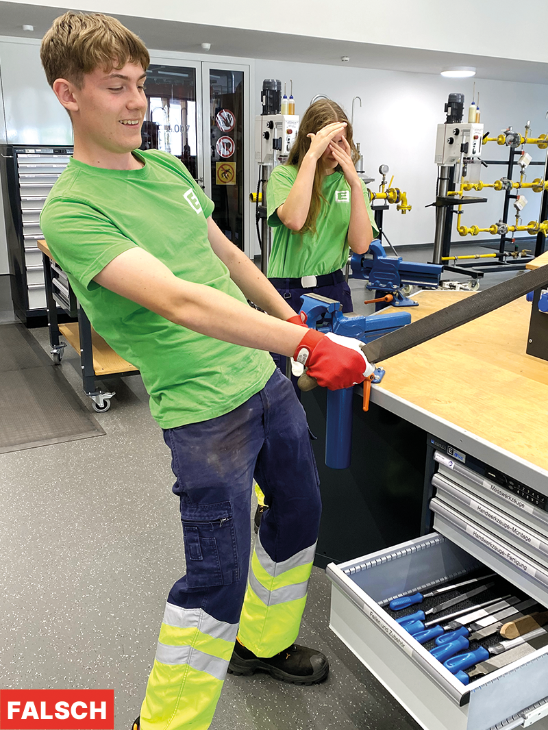 ein junger Mann hält eine Feile in seiner Hand