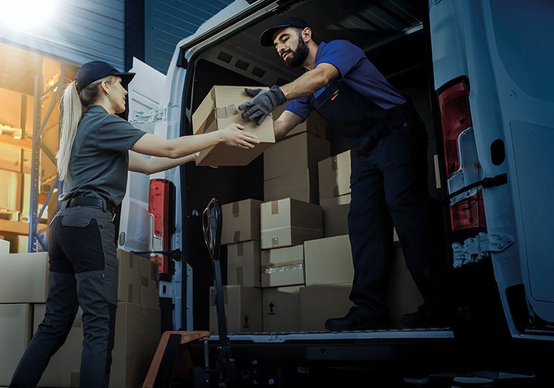 Outside of Logistics Distributions Warehouse: Diverse Team of Workers use Hand Truck Loading Delivery Van with Cardboard Boxes, Online Orders,  E-Commerce Purchases.