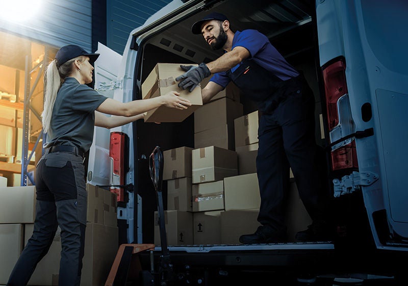 Outside of Logistics Distributions Warehouse: Diverse Team of Workers use Hand Truck Loading Delivery Van with Cardboard Boxes, Online Orders, E-Commerce Purchases.